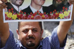 Protester with portraits of Mahmoud Ahmadinejad, Bashar al-Assad and Hassan Nasrallah. Source: www.britannica.com